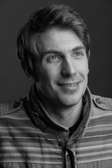 Handsome man against gray background in black and white