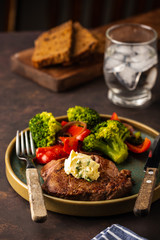 Grilled Beef steak with garlic butter and vegetables. Meat with grilled bell pepper, broccoli and onions.