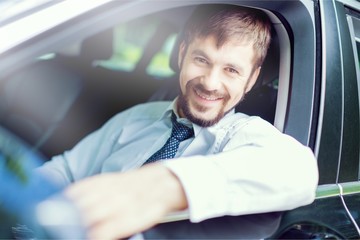Young happy man in car smiling - concept of buying car