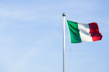 italian flag in the wind on a blue sky background