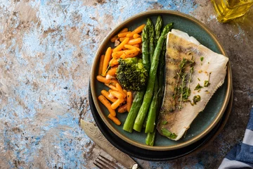 Glasschilderij Vis Pike perch fillet with asparagus, broccoli and carrots. Fried fish with stewed greens