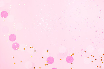 Pink confetti and stars and sparkles on pink background.