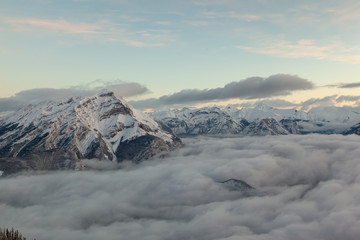Obraz premium Winter birdview of snow capped Cascade Mountain with low cloud from the summit of Sulphur Mountain in Banff National Park in Alberta