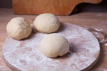 Fototapeta na wymiar The dough is divided into three parts and formed into buns