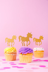Creative pastel fantasy holiday card with cupcake, confetti and unicorn. Baby shower, birthday, celebration concept.