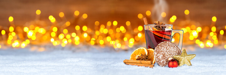 Glühwein lebkuchen und weihnachten dekoration auf schnee vor bokeh lichterhintergrund / hot spiced...