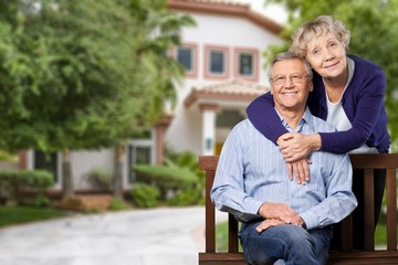 Close-up portrait of an elderly couple hugging in park