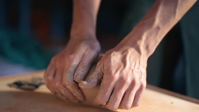 Pottery and ceramic. Sculptor is pugging and kneading clay on table