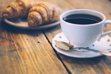 Black coffee and croissant. Typical French Breakfast (Petit Déjeuner) background.