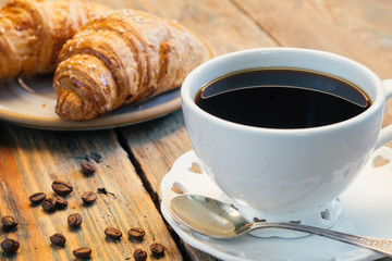 Black coffee and croissant. Typical French Breakfast (Petit Déjeuner) background.