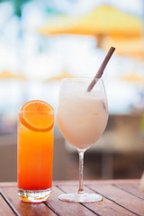 two perfect exotic cocktails on the table, pool background