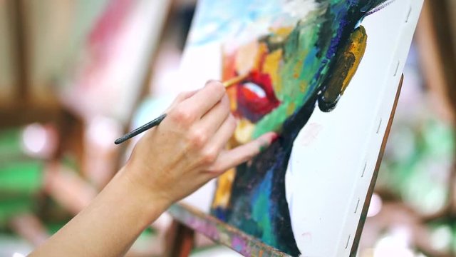 Woman paints a painting on canvas. Art academy or drawing school.