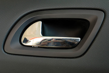 Modern chrome car door handle from inside close