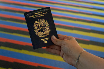 Woman showing venezuelan passport in International Airport Simon Bolivar Maiquetia La Guaira Vargas...