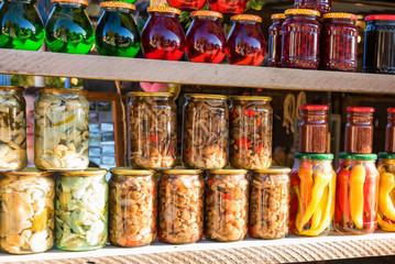 Preserved autumn vegetables and jam in jars