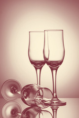 Three empty champagne glasses on colored background