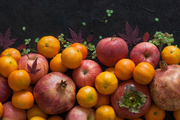 Fototapeta na wymiar Italian autumn harvest: garnet, mandarins, persimmons, apples.