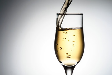 One elegant glass with sparkling champagne with splash