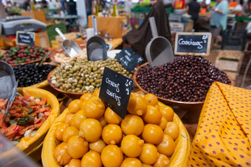Im Markt aufgehäufte Orangen und Oliven mit kleinen Schaufel eingesteckt