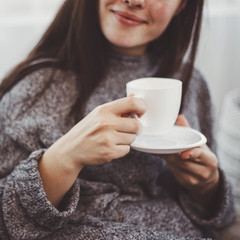 Cozy young woman enjoy morning coffee, close up. Comfort, home, joy concept
