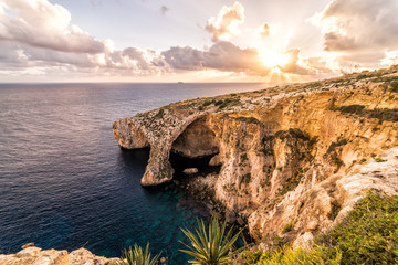 Sunset over the "Blue Grotto".  A famous arch rock formation on the island country of Malta.  Located in the Mediterranean Sea, Europe.  