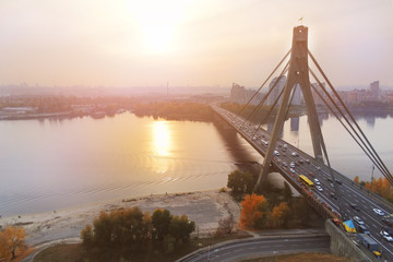 Fototapeta na wymiar Moscow bridge in Kiev at sunset evening time . Ukraine capital cityscape. Traffic on road. Aerial drone view