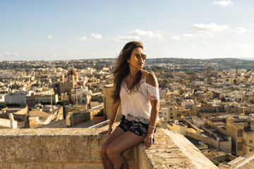 Woman sitting atop the medieval Gozo Citadel castle.  