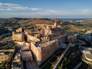 Aerial drone photo - The Gozo Citadel at sunset.  A medieval fortress in the city of Victoria (Rabat).  Island of Gozo, Malta.