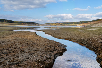 View to the dam wall of a dam with low water level, the dryness is clearly visible, consequence of...