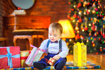 Fototapeta na wymiar baby is sitting on the float on the background of the Christmas tree