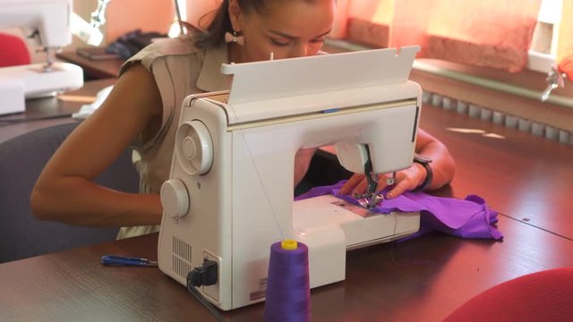 Woman stitching fabric using a sewing machine