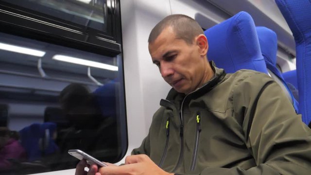 traveler unknown middle-aged man smartphone in the subway writes sms to social media messenger. slow motion video. man metro in railway train. man lifestyle traveler in train concept travel