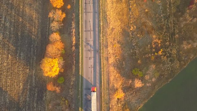 Aerial: fly cam follow motorbike on the road at sunset time