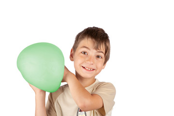 Cheerful young boy holding a green slime balloon. Studio shot isolated on white background.