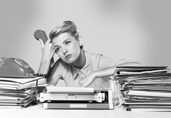 Young blonde female writer using typing machine, black and white