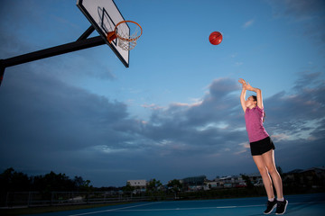 Girl shooting a basketball at an outdoor court © scottdavis2