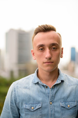 Obraz premium Face of young handsome man outdoors in city