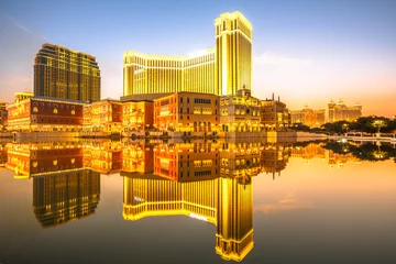 Zelfklevend Fotobehang Spectaculaire gouden skyline van Macau in China, weerspiegeld in het water bij schemering. © bennymarty