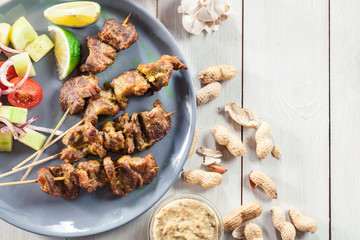 Traditional pork satay with peanut sauce and vegetables