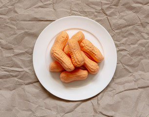 Old-fashioned circus peanuts on a plate with brown paper background.