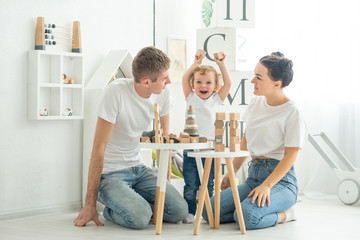 Fototapeta premium the family teaches the child how to play in a large bright room, concept development games, child development, study