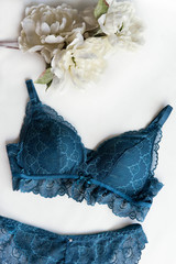 Blue bra on the white background with flowers.Close up