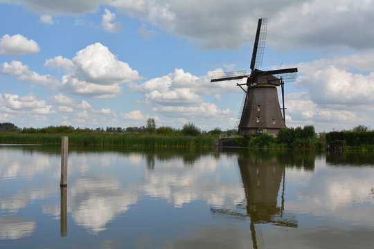 Windmill in a field near a small river in Holland