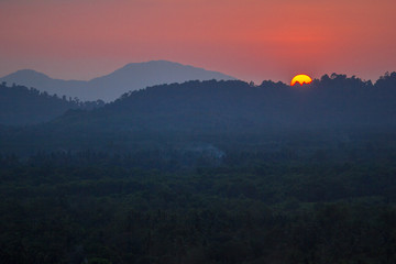 The background of the big sun, which is going to hide the mountains, and the light of the evening light, beautiful colors, beautiful nature of the season.