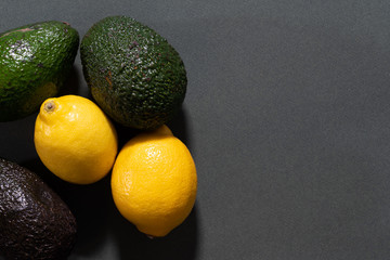 Lemons and avocados on gray background