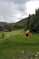 Golfer teeing off in Vail Colorado - obrazy, fototapety, plakaty