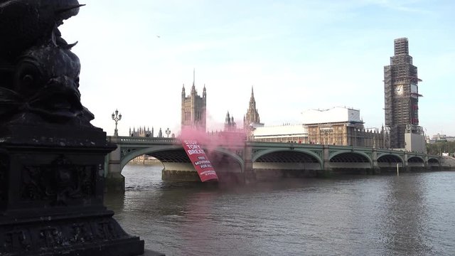 UK October 2018 - Another Europe is Possible campaign group protestors hang a large red banner from Westminster Bridge that says, &sbquo;&Auml;&uacute;Stop Tory Brexit, Free Movement For All&sbquo;&Auml;&ugrave; and light red smoke flares.