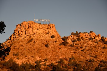 Low angle view of the city of Trinidad Colorado landmark sign with an early sunrise glow against...