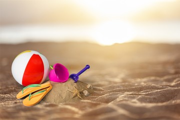 Flip-flops with ball and toys on sandy