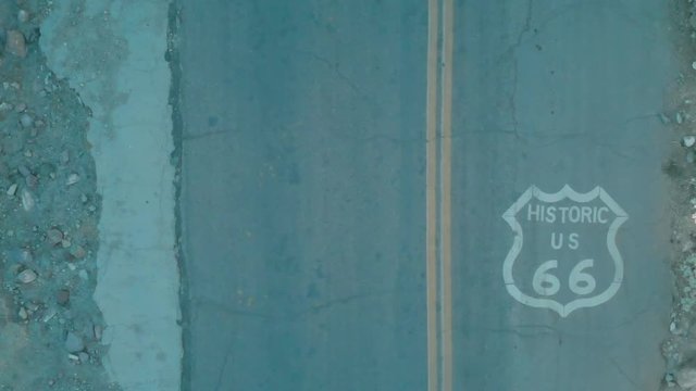 Aerial footage of Route 66 with the Route 66 shield and a red truck passing in the other lane